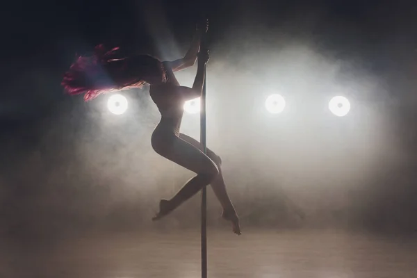 Joven mujer delgada pole bailando en interior oscuro con luces y humo . — Foto de Stock