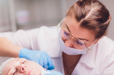 Kadının yüzüne, closeup enjeksiyon yapma güzellik uzmanı. Biorevitalization yordamı.