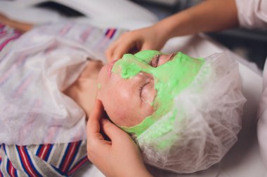 Yeşil algler genç bir kadının yaşlanmaya karşı tedavi spa maskeden özel makyaj fırça yardımıyla güzellik uzmanı yapar.
