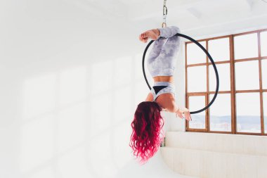 Hava acrobat içinde belgili tanımlık çalmak. Genç bir kız akrobatik öğeleri hava ringde gerçekleştirir..