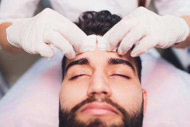 Kadın eller temizlik Mans yüz pamuk bezlerden ile bir spa merkezi.