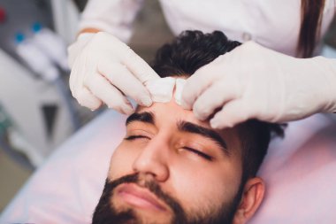 Kadın eller temizlik Mans yüz pamuk bezlerden ile bir spa merkezi.