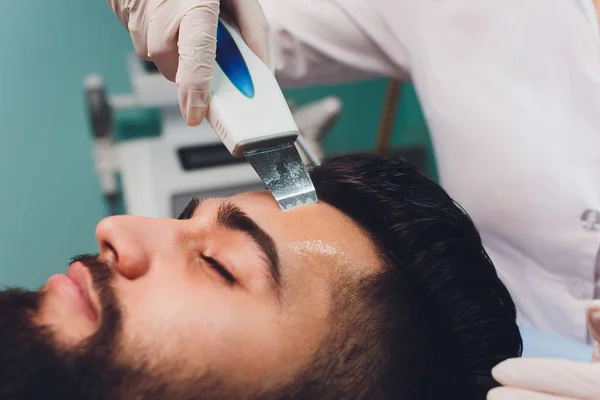 Limpieza ultrasónica del rostro. Hombre joven caucásico, cosmetología . —  Fotos de Stock