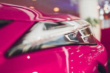 Lüks pembe araba arka planda shot Far kapatın. Modern ve pahalı spor araba konsepti.