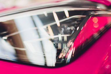 Lüks pembe araba arka planda shot Far kapatın. Modern ve pahalı spor araba konsepti.