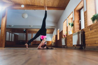 Yoga kavramı pratik genç Yogi çekici kadın, sancak karasan egzersiz ayakta, amuda kalkma poz, çalışma dışarı, spor giyim, siyah tank üst ve pantolon, tam uzunlukta, çatı arka plan giymek.