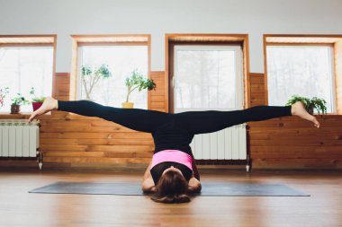 Omuz stand poz, çalışma dışarı Sirasana Sarvangasana egzersiz, pratik yoga, Genç sportif çekici kadının yapması desteklenen, giyiyor spor giyim, pantolon ve üst, kapalı beyaz yoga stüdyosu, yakın.