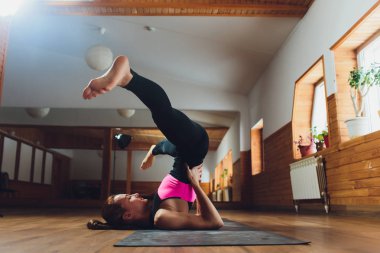 Omuz stand poz, çalışma dışarı Sirasana Sarvangasana egzersiz, pratik yoga, Genç sportif çekici kadının yapması desteklenen, giyiyor spor giyim, pantolon ve üst, kapalı beyaz yoga stüdyosu, yakın.