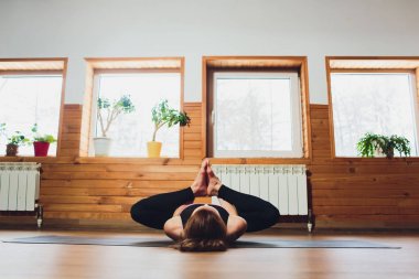 Sportif kadın pratik yoga, ardha Padmasana egzersiz, yarım Lotus poz mudra hareketi ile çalışma dışarı yaparak spor giyim gri pantolon ve üst, cesedi yakın, yoga stüdyosu giyiyor. Dikkatli hayat kavramı