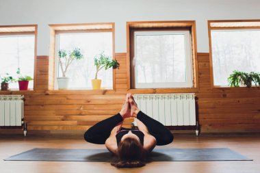 Sportif kadın pratik yoga, ardha Padmasana egzersiz, yarım Lotus poz mudra hareketi ile çalışma dışarı yaparak spor giyim gri pantolon ve üst, cesedi yakın, yoga stüdyosu giyiyor. Dikkatli hayat kavramı