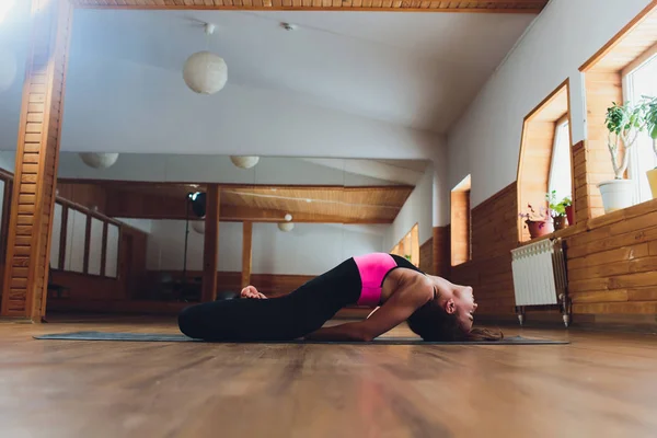 Giovane yogi donna attraente pratica concetto di yoga, in piedi in salamba sirsasana esercizio, poggiatesta posa, lavorare fuori, indossando abbigliamento sportivo, canotta nera e pantaloni, tutta la lunghezza, loft sfondo — Foto Stock