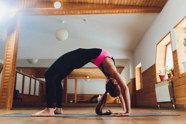 Hermosa mujer practica backbend yoga asana Urdhva Dhanurasana - pose de arco hacia arriba en el estudio de yoga . — Foto de Stock