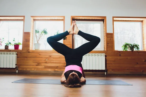 Donna sportiva che pratica yoga, facendo esercizio Ardha Padmasana, mezza Lotus posa con gesto mudra, allenarsi, indossare pantaloni grigi abbigliamento sportivo e top, corpo da vicino, studio di yoga. Concetto di vita consapevole . — Foto Stock