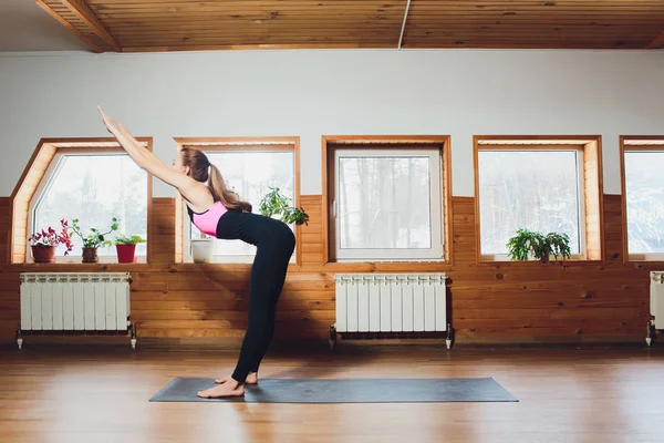 Mujer caucásica está practicando yoga en el estudio padahastasana . — Foto de Stock