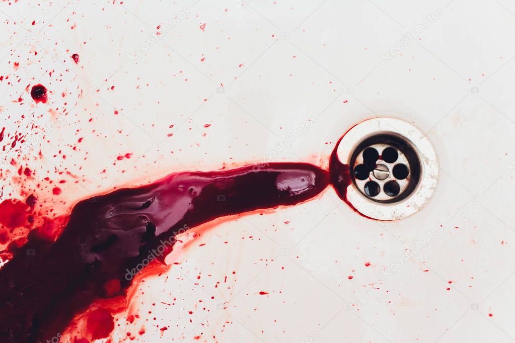 Blood draining from white bathroom basin. Bloody stains in the waterbasin hole. Sink run with blood floods. Red paint dripples to the washbowl drain. Accident with human injury. Bleeding in bathroom.