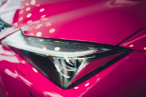 Z bliska strzał reflektorów w tle różowy samochód luksusowy. Nowoczesne i drogie sport concept car. — Zdjęcie stockowe