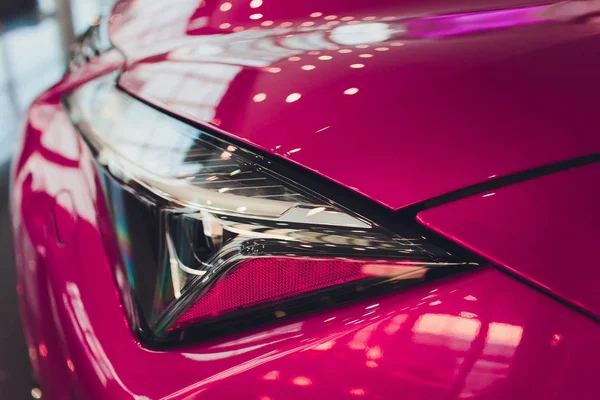 Nahaufnahme Shot Scheinwerfer in Luxus-rosa Auto Hintergrund. Modernes und teures Sportwagen-Konzept. — Stockfoto
