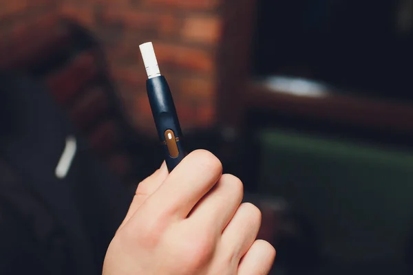 Tecnologia dei prodotti del tabacco non bruciati termicamente. Donna che tiene la sigaretta elettronica in mano prima di fumare. — Foto Stock