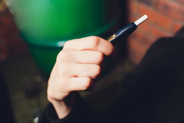 Technologie für hitzebeständige Tabakerzeugnisse. Frau hält vor dem Rauchen E-Zigarette in der Hand. — Stockfoto