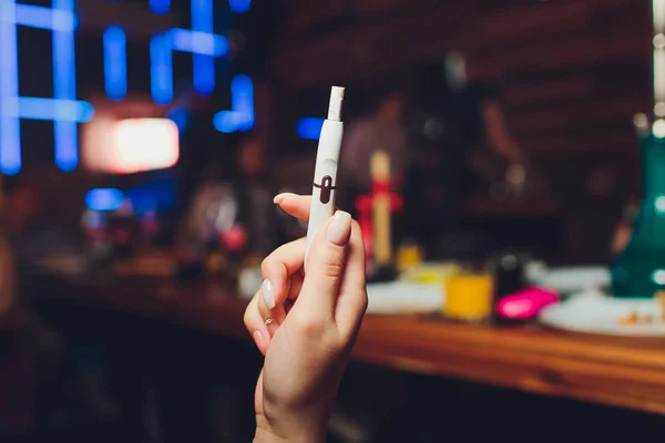 Tecnologia dei prodotti del tabacco non bruciati termicamente. Donna che tiene la sigaretta elettronica in mano prima di fumare. — Foto Stock