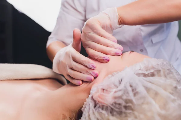 Cosmetólogo hace un masaje bucal de los pacientes músculos faciales . — Foto de Stock