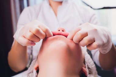 Kozmetolog hastaların yüz kasları bir bukkal masaj yapar.