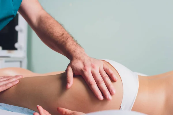 Massage anti-cellulite sur les jambes des jeunes femmes . — Photo