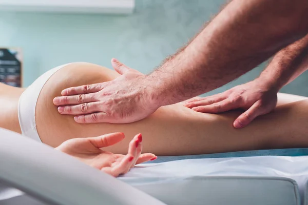 Anti-cellulitis massage op de benen van jonge vrouwen. — Stockfoto