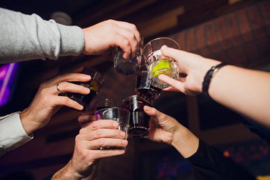 Ellerinde viski ya da şarap bardakları olan insanların elleri düğünün ya da diğer kutlamaların şerefine kadeh kaldırıyor ve kutluyor..