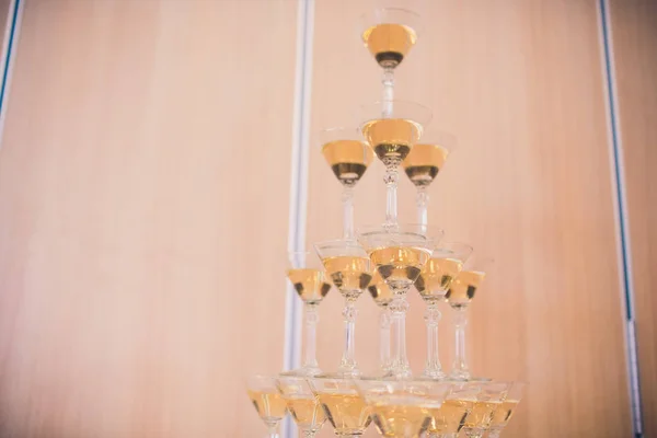 Champagne glasses standing in a tower at the party.