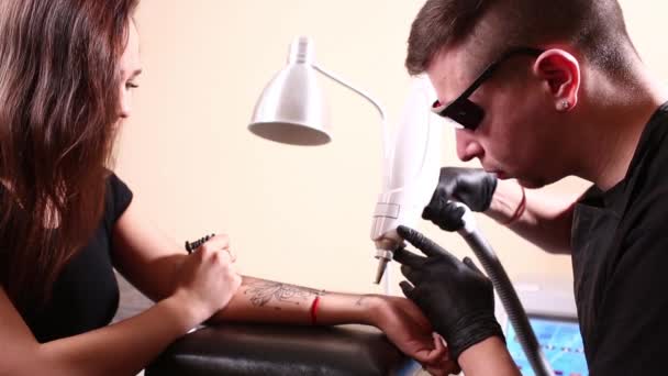Cosmetologist with patient and professional tattoo removal laser in salon. — Stock Video
