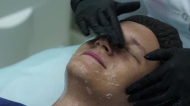 Erkek kozmetolojisi. Güzellik kliniğinde yüz ameliyatı olan genç erkek. Peeling cilt.