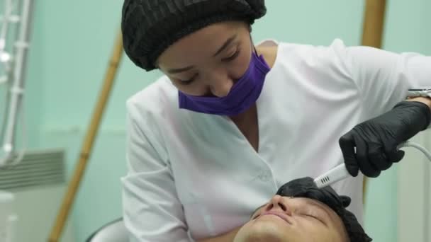Mannen s cosmetologie. Jonge mannelijke ontvangen gezichtsbehandelingen in Beauty Clinic. Schil huid. — Stockvideo
