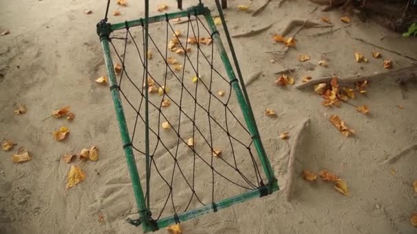 Hamac vide entre les palmiers à la plage de sable.