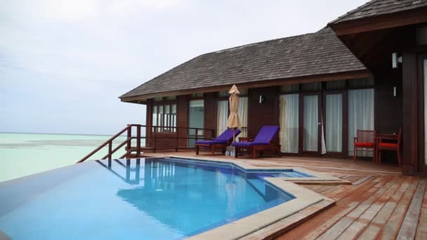 Özel havuz ve gündüz yatakları ile lüks okyanus villa terası. — Stok video