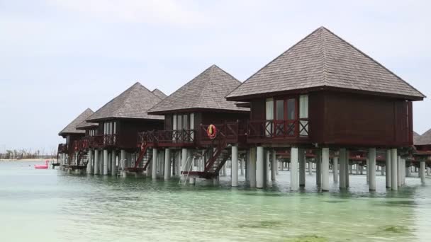 Au-dessus des bungalows d'eau avec des étapes dans la lagune verte étonnante . — Video