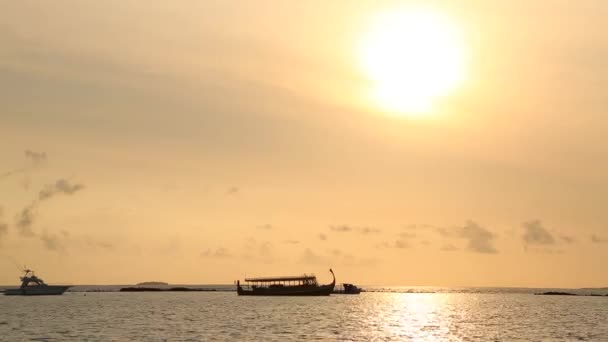 Smidig Timelapse av färgglada solnedgång på ön i Maldiverna med orange himmel, mörka moln och ö vid horisonten. Solen sätter sig över horisonten. Frånvaro av människor. — Stockvideo