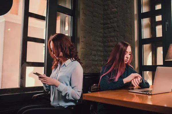 Dos estudiantes o lesbianas que se divierten durante el descanso de café en la cafetería, la segunda mitad distraen del trabajo . — Foto de Stock