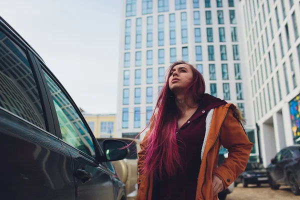 Jolie jeune femme debout et à la recherche de clés de voiture dans son sac à l'extérieur . — Photo