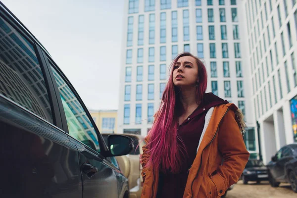 Jolie jeune femme debout et à la recherche de clés de voiture dans son sac à l'extérieur . — Photo