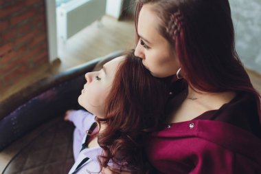 Lgbt Sevimli genç kızlar gülümseyerek ve evde kanepede flört.