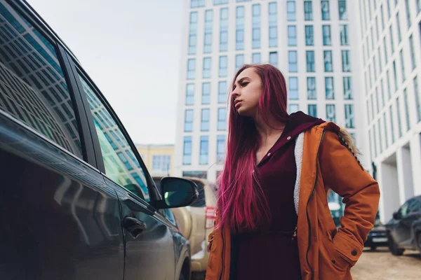 Mulher muito jovem de pé e olhando chaves de carro em sua bolsa ao ar livre . — Fotografia de Stock