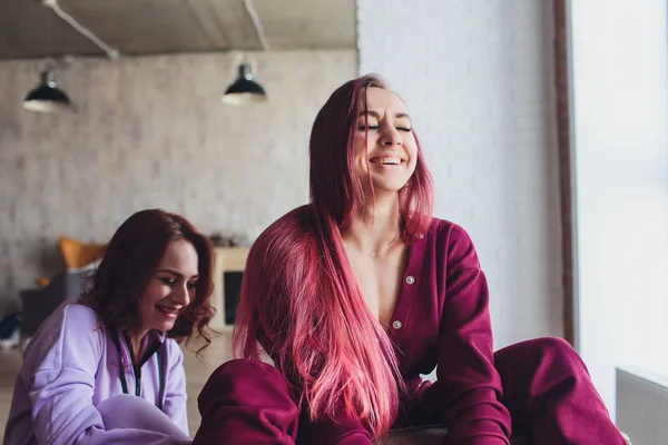 LGBT Bonito meninas sorrindo e flertando no sofá em casa . — Fotografia de Stock