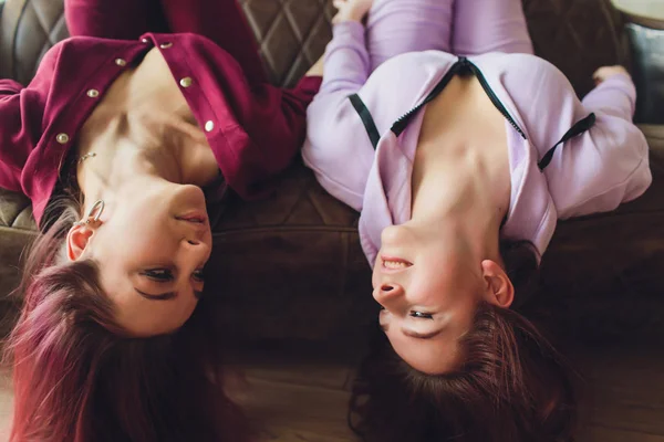 LGBT Bonito meninas sorrindo e flertando no sofá em casa . — Fotografia de Stock