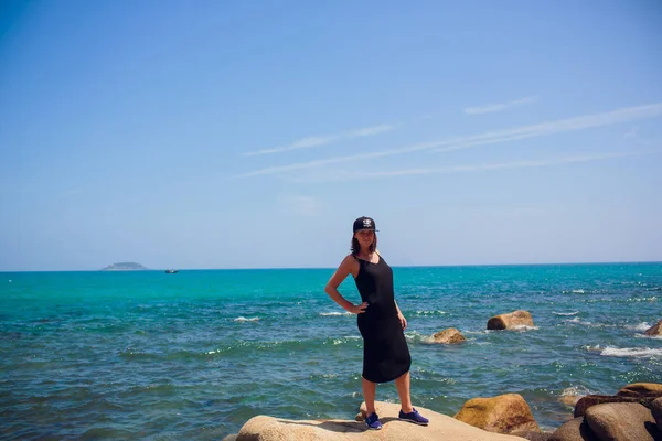 Жінка мандрівник сидить і дивиться на край скелі на березі моря Азія . — стокове фото