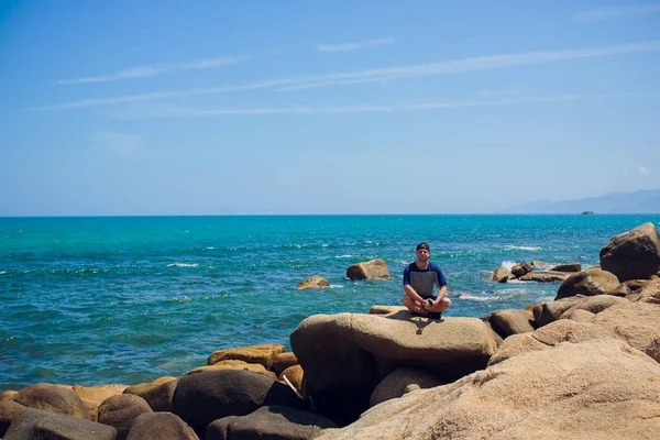 Donna viaggiatore si siede e guarda il bordo della scogliera sulla baia del mare asia . — Foto Stock