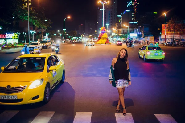 Nha trang, vietnam - 17. februar 2018: schönes mädchen auf dem hintergrund einer nachtstraße in asien. — Stockfoto