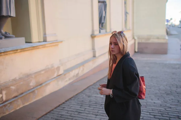 Schönes Mädchen in schwarzem Mantel spaziert durch die Stadt. — Stockfoto