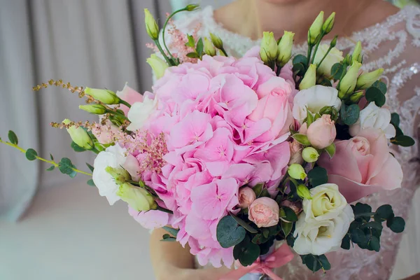 Die Braut hält einen Strauß der Braut aus weißen Rosen und Eustoma. — Stockfoto