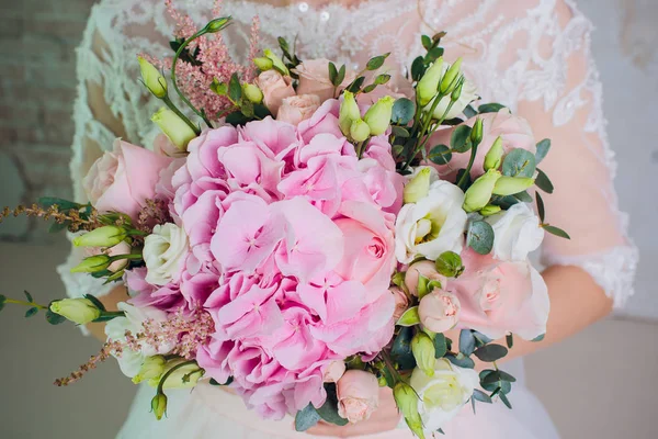 Die Braut hält einen Strauß der Braut aus weißen Rosen und Eustoma. — Stockfoto